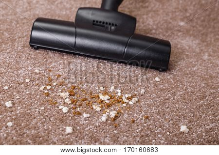 Vacuuming carpet with vacuum cleaner. Dirt on the rug. Housework service. Close up of the head of a sweeper cleaning device.