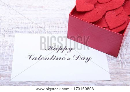 Valentine card with box red heart on wooden desk.
