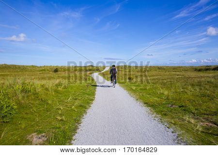 People cycling on a bike path through the dune landscape of Frisian Island Amsland the Netherlands
