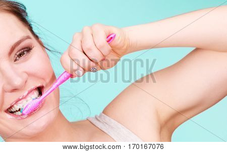 Woman brushing cleaning teeth. Girl with toothbrush close up. Oral hygiene. Blue green background