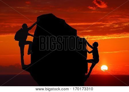 Teamwork couple hiking help each other trust assistance silhouette in mountains sunset. Teamwork of man and woman hiker helping each other on top of mountain climbing team