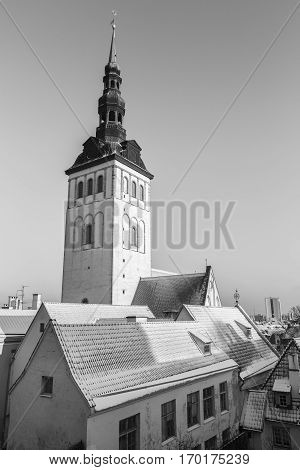 Black and white view of St. Nicholas' Church Spire with roofs with snow,Tallinn Estonia