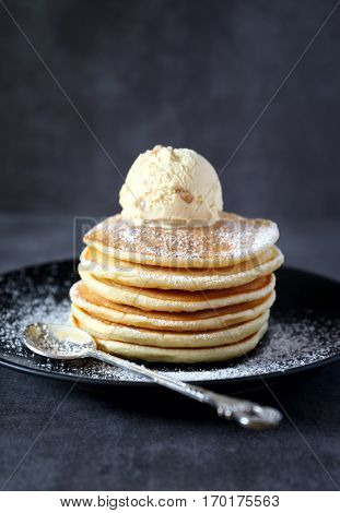 Pancakes with ice cream on the dark background
