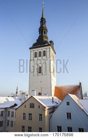 St. Nicholas' Church Spire viewed from the park with snow and a dead tree,Tallinn Estonia