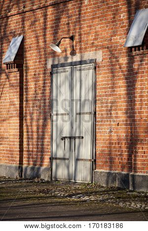 red brick wall and wooden door with vintage lamp