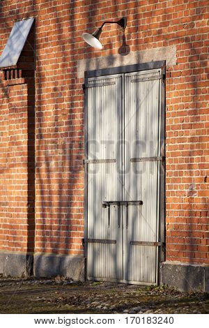 red brick wall and wooden door with vintage lamp