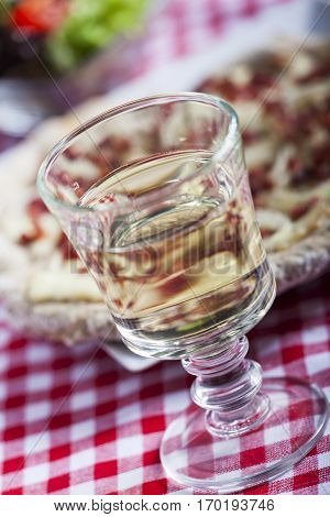 closeup of white wine and flammkuchen on plaid
