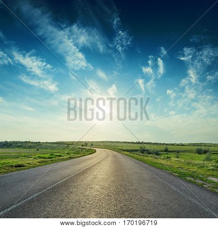 sunset in deep blue sky over asphalt road