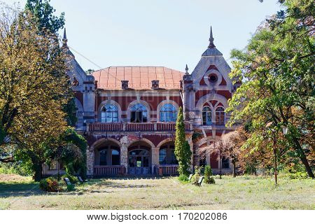 Taul Park, alley with benches, old ruined entrance main red building, north of Moldova
