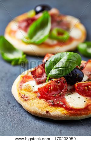 Mini pizza topped with cherry tomatoes and basil