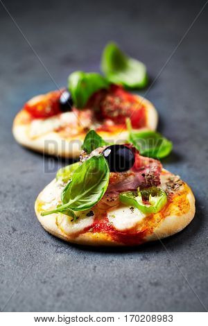 Mini pizza topped with cherry tomatoes and basil