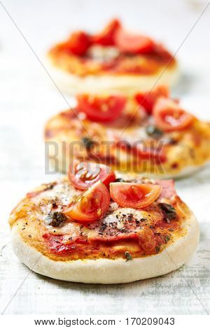 Mini pizza topped with cherry tomatoes and capers