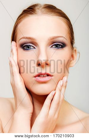 Attractive blonde topless woman with dark eye make up