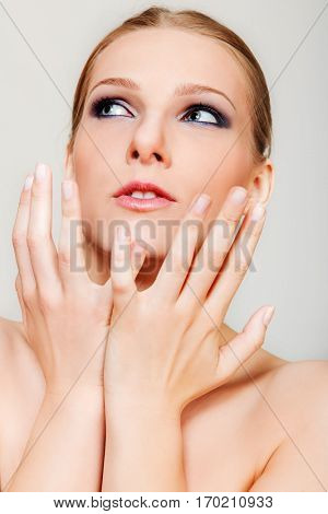 Attractive blonde topless woman with dark eye make up