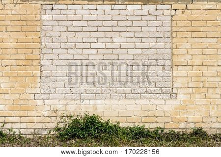 Old gungy white brick wall with bricked up window