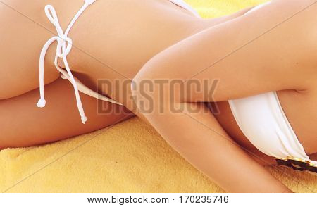 A part of a female body in a white swimsuit lying, isolated on white abckground