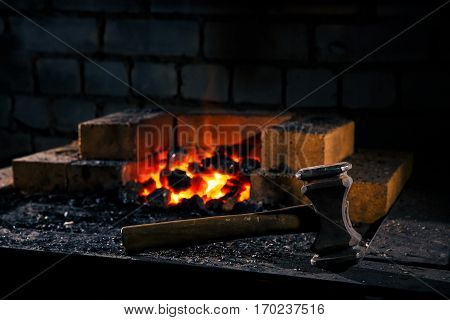 Blacksmith hammer on the anvil against the background of fire