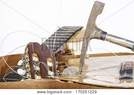 An acoustic guitar that has been smashed with a hammer by its frustrated guitarist owner. No more music practice.