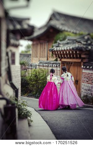 SEOUL - SOUTH KOREA - OCTOBER 21 2016 : A couple women wander through the traditional style houses of Bukchon Hanok Village in Seoul South Korea.