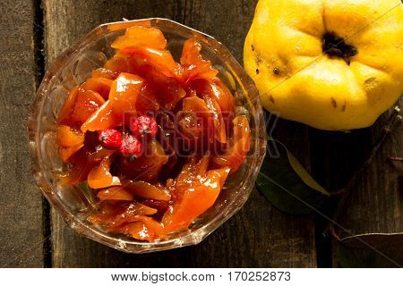 Jam made from apples and quince on wood background