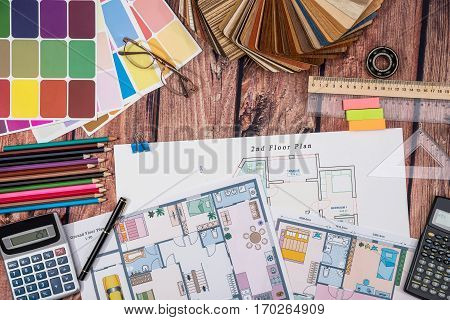 house floor paper plan and wooden sampler work tolls calculator on wooden table.