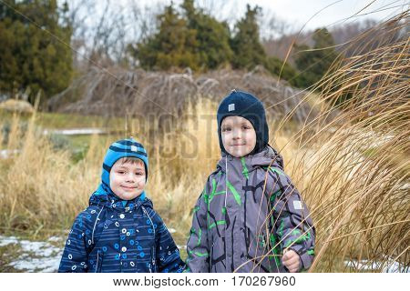 Two Little Kids Boys, Friends Holding Hands And Hugging. Adorable Siblings In Bright Colorful Clothe