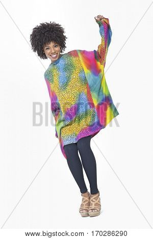 Full length portrait of an African American woman in dashiki standing over gray background