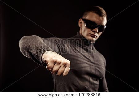 Right-hander punch. Close-up of a man's fist. Sunglasses. Studio shot.