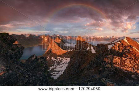 Norway. The island of Senja. Rainbow over a fjord Steinfjorden