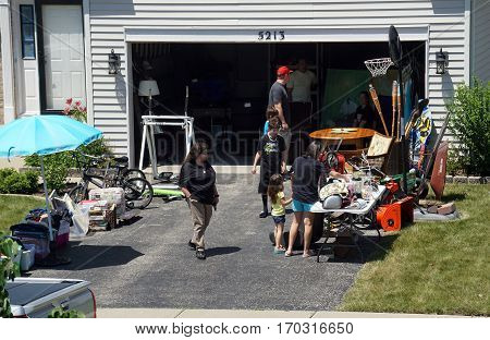 JOLIET, ILLINOIS / UNITED STATES - JUNE 17, 2016: People shop at a garage sale in the Wesmere Estates neighborhood of the Wesmere Country Club in Joliet.