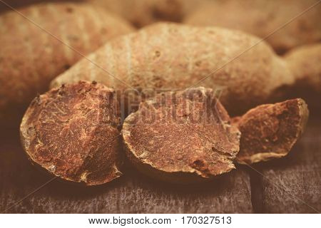 Whole with pieces of turmeric on wooden surface