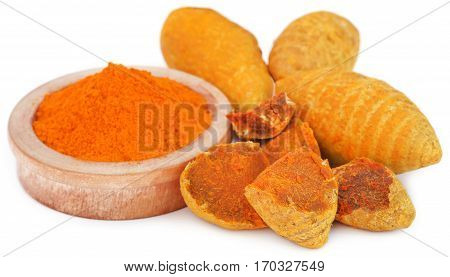 Whole and ground turmeric in bowl over white background