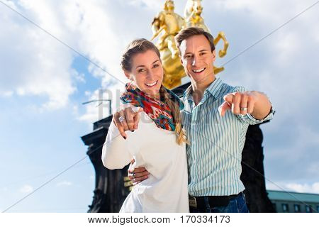 Tourist couple in Dresden in front of Goldener Reiter statue