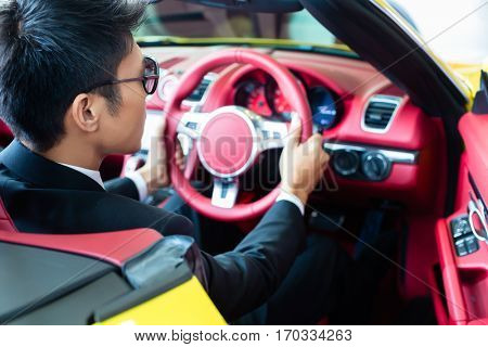 Asian man testing new sports car