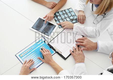 Team of doctors exploring lungs roentgenogram in clinic
