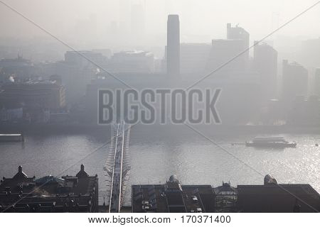 LONDON, ENGLAND - JANUARY 23, 2017: Tate Modern and Millennium Bridge covered in thick fog. Aerial view from St Paul's, London.
