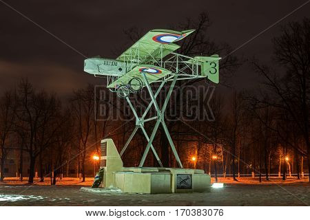 Gatchina Russia - February 10 2016: Monument in honor of the 100th anniversary of the first military airport in Russia. Airplane Model Foreman. Night Photography. Side view.