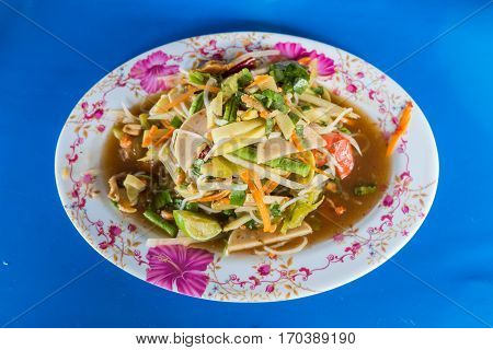 green papaya spicy salad Thai style on blue background