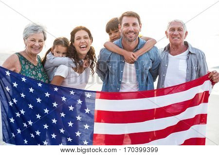 Happy family with an american flag at the beach