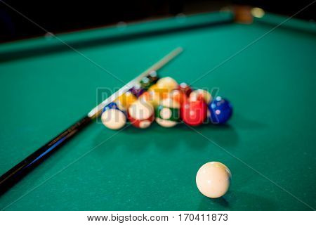 billiard table with billiard balls, cue and billiard triangle