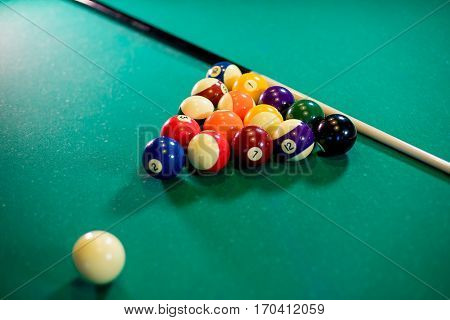 billiard table with billiard balls, cue and billiard triangle