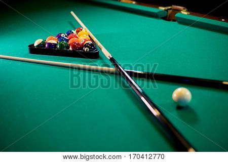 billiard table with billiard balls, cue and billiard triangle