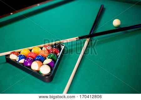 billiard table with billiard balls, cue and billiard triangle