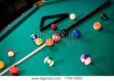 billiard table with billiard balls, cue and billiard triangle