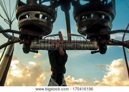 Man controlling hot air balloon by the tip of his finger during Sunset rider over Vang Vieng, Laos