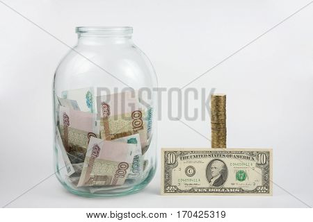 Close To Three-liter Jar Filled With Money Is A Stack Of Coins Next To It Is A Banknote Of Ten Dolla
