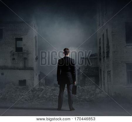 Businessman standing over apocalyptic background. Crisis, default, setback concept.