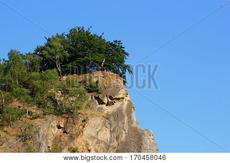 A wooded rock and bright blue sky