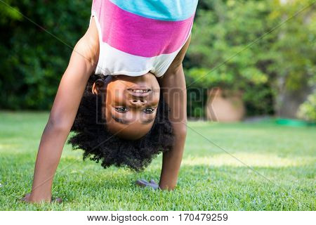 A kid doing a headstand in garden
