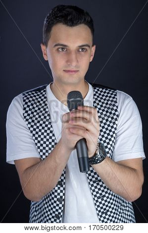 Young Male Black-haired Rock Singer Performs Singing To Microphone